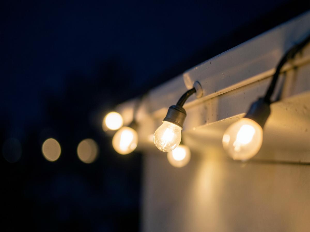 Close-up of warm white C9 Christmas bulbs clipped along a roofline